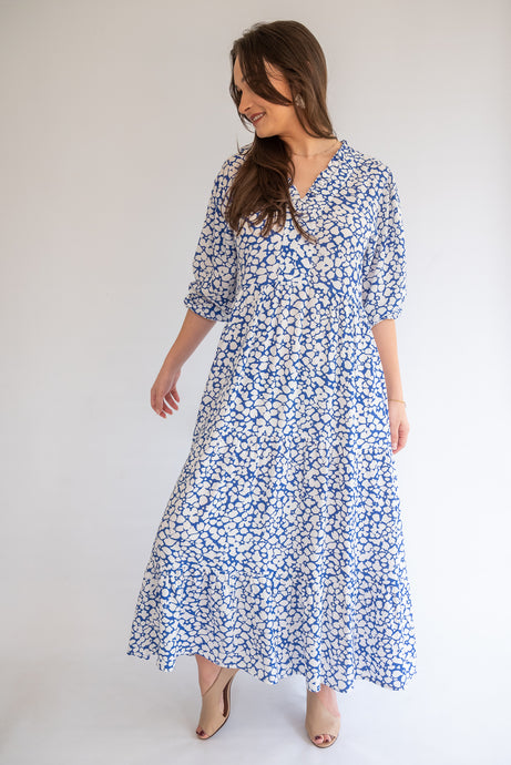 Woman wearing a blue floral dress against a white background